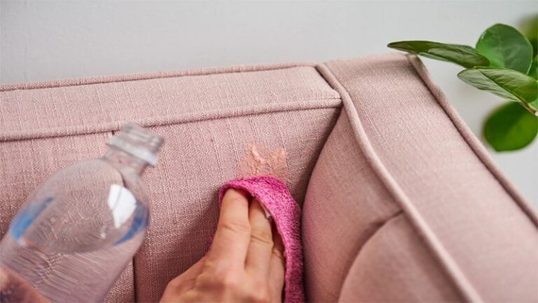پاک کردن اسلایم از روی مبل با دستمال و یک محلول توسط یک فرد