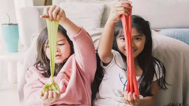 دو کودک دختر که با اسلایم بازی می‌کنند